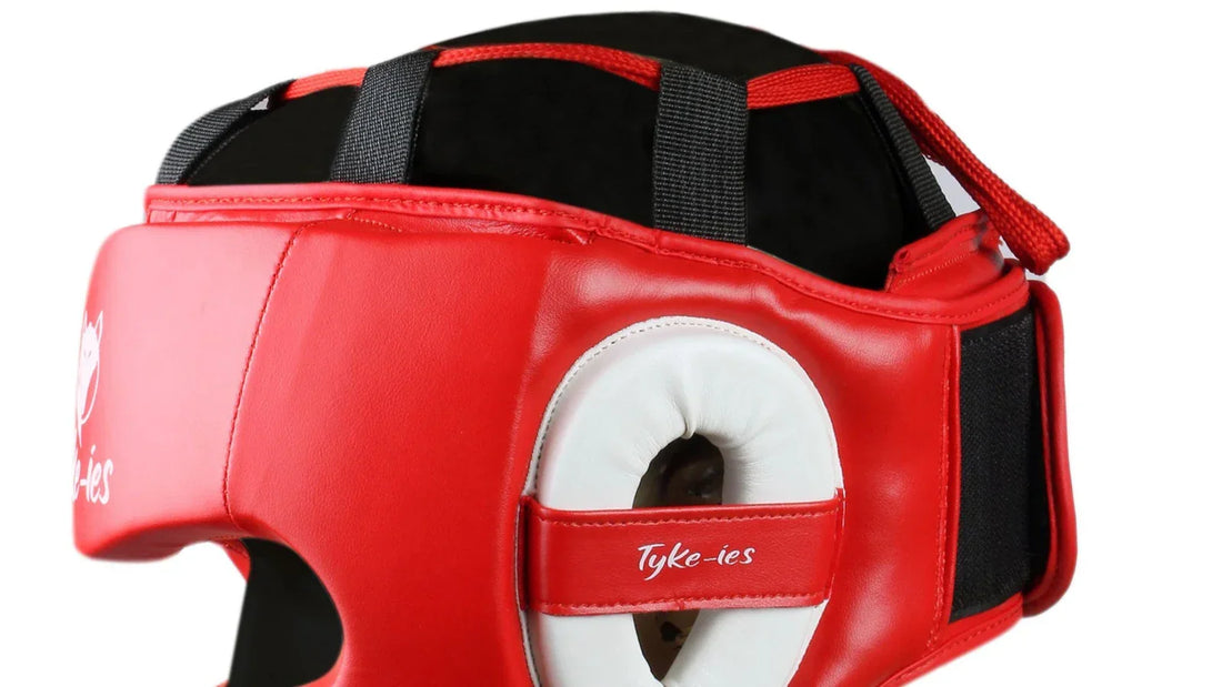 Close up of Tyke-ies red boxing headgear with secure black straps on a white background