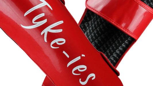 Tyke-ies shin guards close-up displaying impact dispersing padding and sweat wicking anatomical fit.